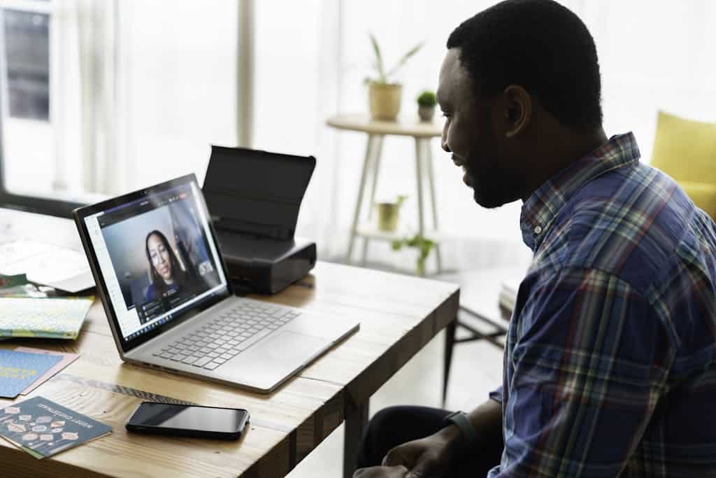 A Man in Blue Plaid Long Sleeves Using a Laptop